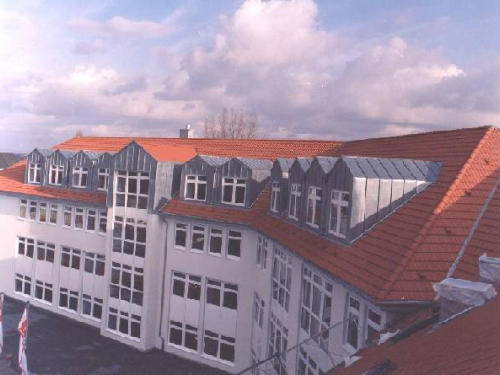Großes Gebäude mit Ziegeldach und Metallgauben